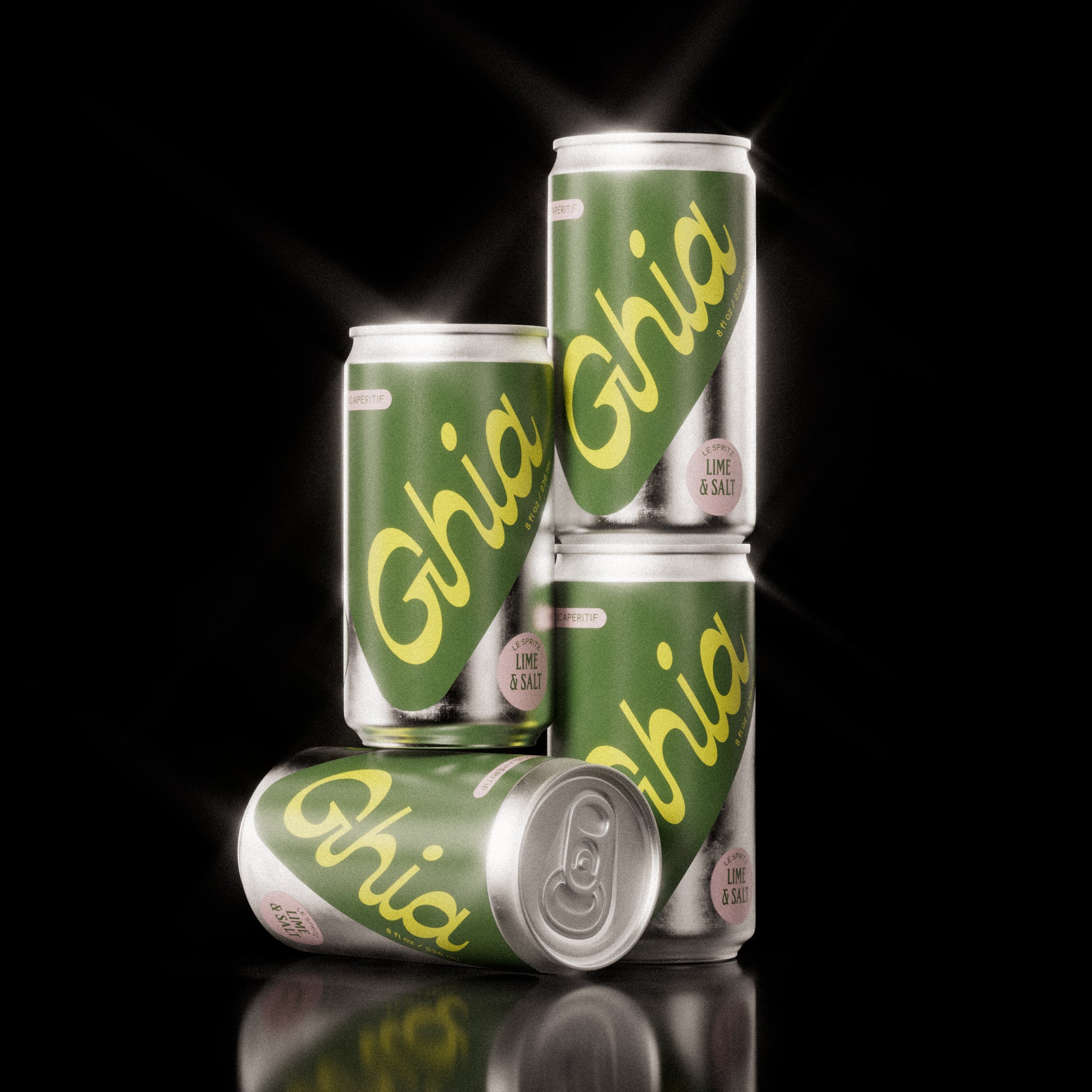Four Ghia Lime & Salt non-alcoholic spritz cans stacked in a pyramid on a reflective black surface, featuring green labels and bold yellow branding.