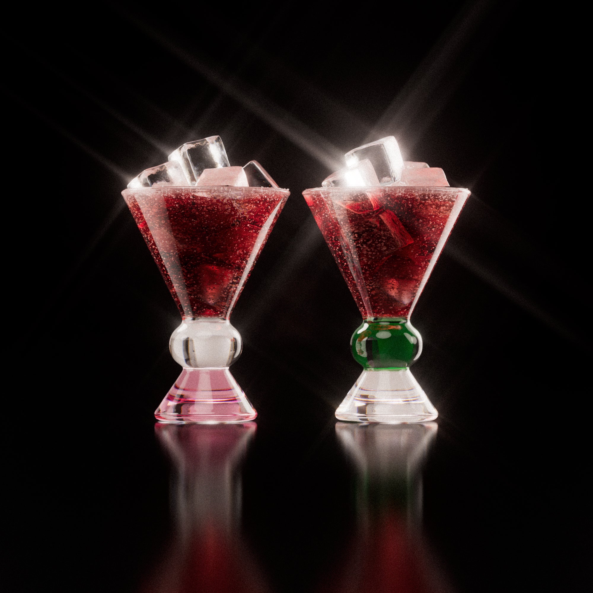 Two decorative glasses that have a pink, clear and green base, each containing a red drink with ice cubes, highlighting the distinctive totem-inspired shape of the glasses against a light background.