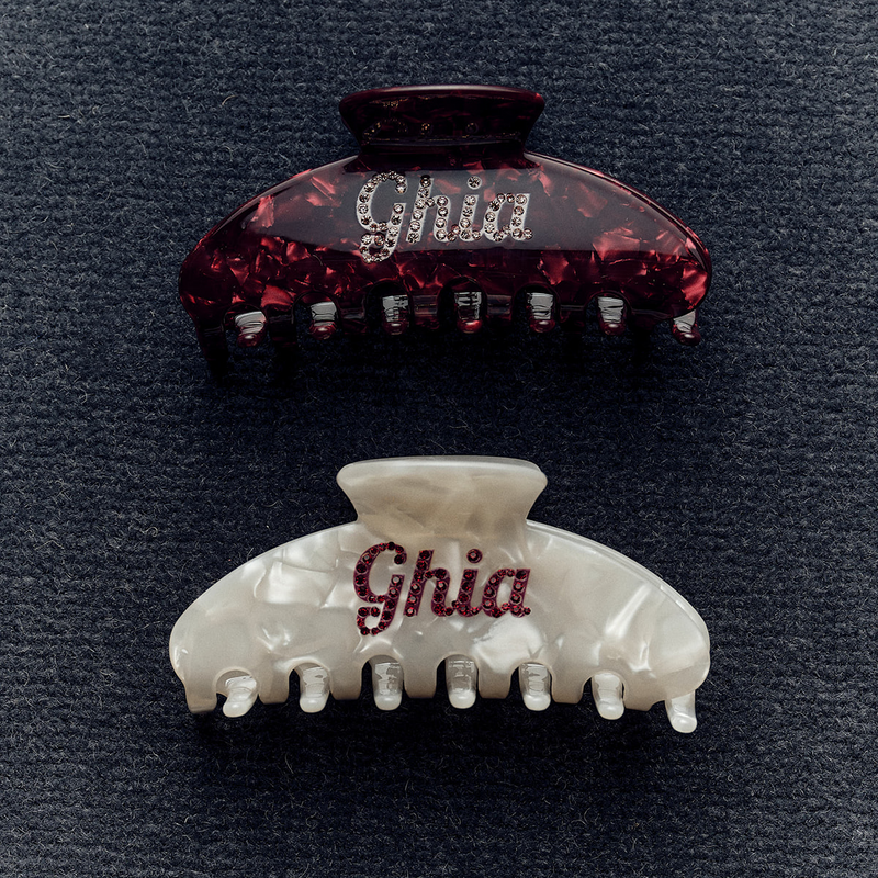 Two Ghia claw clips with script logo, one burgundy tortoiseshell and one pearl white