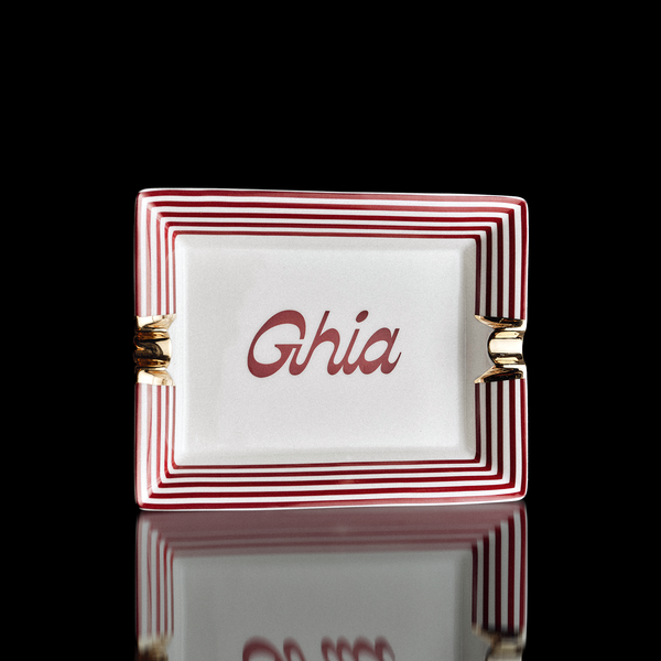 Ghia vide-poche ceramic tray with red and white striped border, gold accents and Ghia script in the center