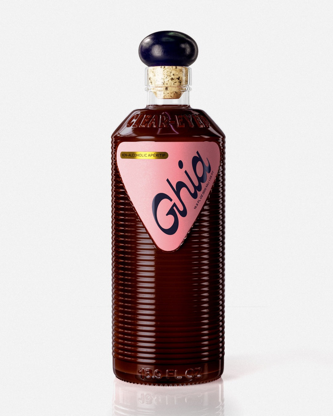 A Ghia non-alcoholic beverage in flavor Berry Apéritif clear bottle with ribbed glass, a purple cork top, and a pink label featuring bold branding on a reflective surface.