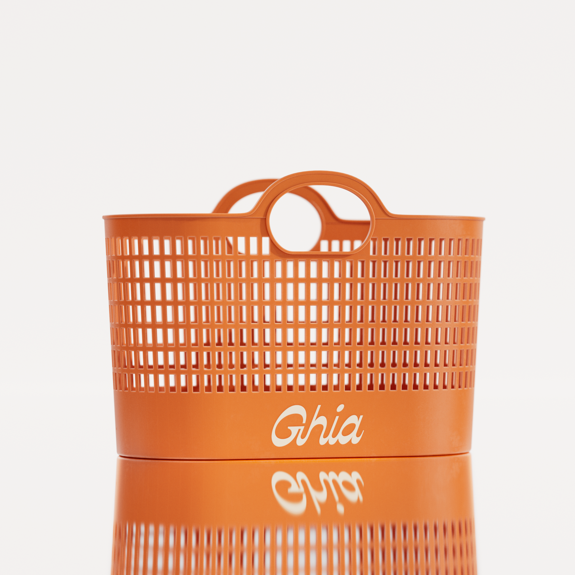 An orange Ghia-branded plastic tote basket with a perforated design, rounded handles, and bold white lettering on the front.