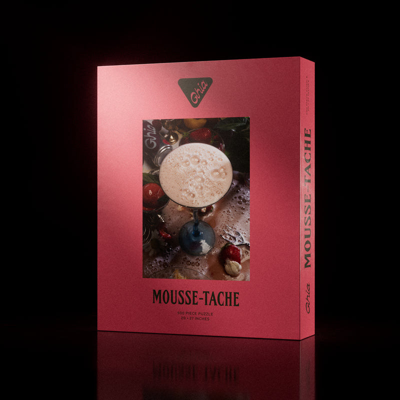 Ghia "Mousse-Tache" 500-piece puzzle box, featuring a whimsical illustration of a frothy cocktail glass surrounded by various ingredients and objects.
