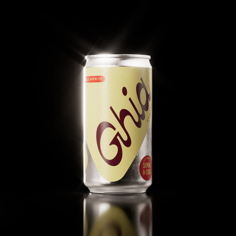 A Ghia non-alcoholic spritz can with a yellow label, burgundy lettering, and a silver aluminum body, featuring a sumac and chili flavored non-alcoholic spritz beverage.