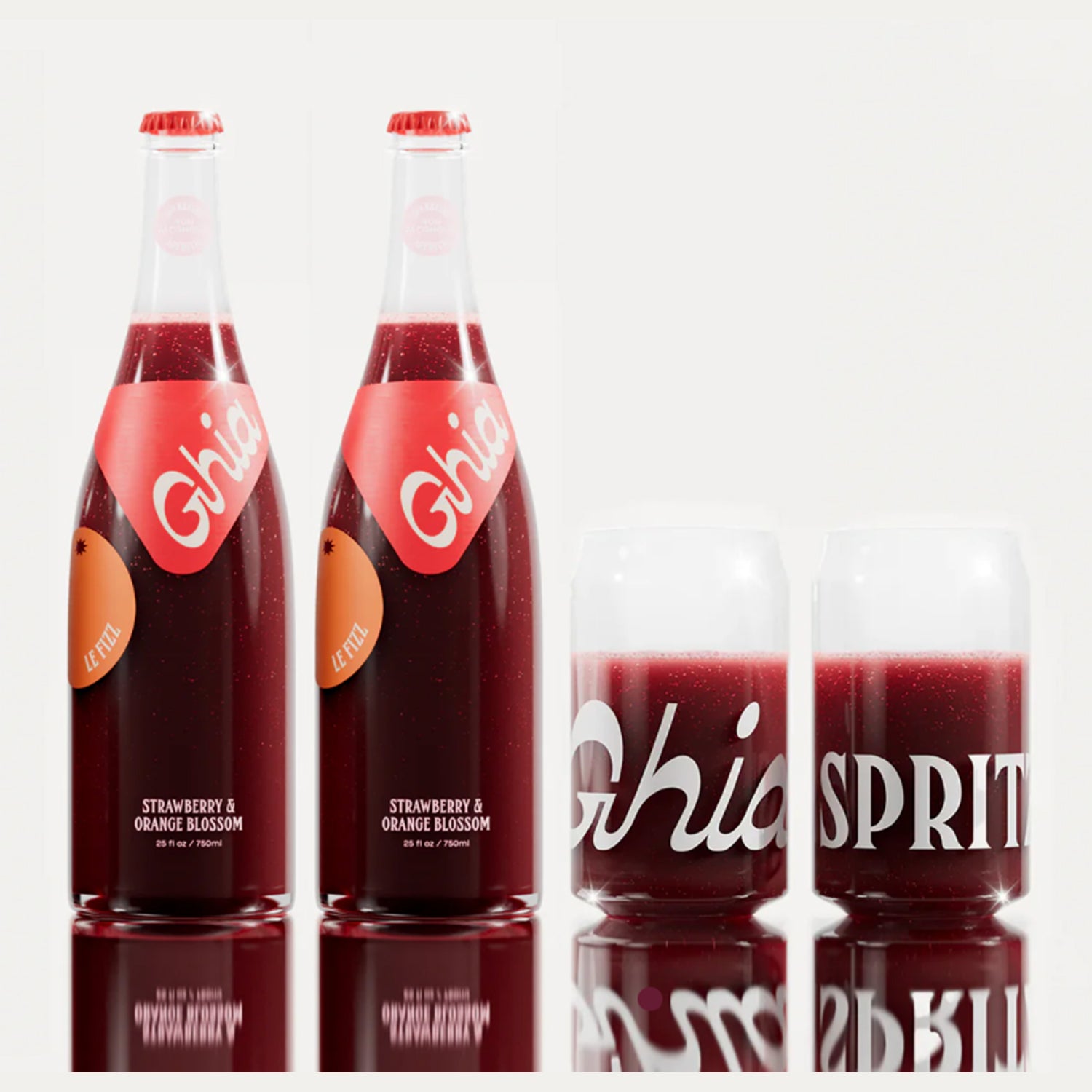 Two non-alcoholic spritz Ghia Strawberry & Orange Blossom bottles with red labels alongside two clear glasses filled with the beverage, featuring bold white text.