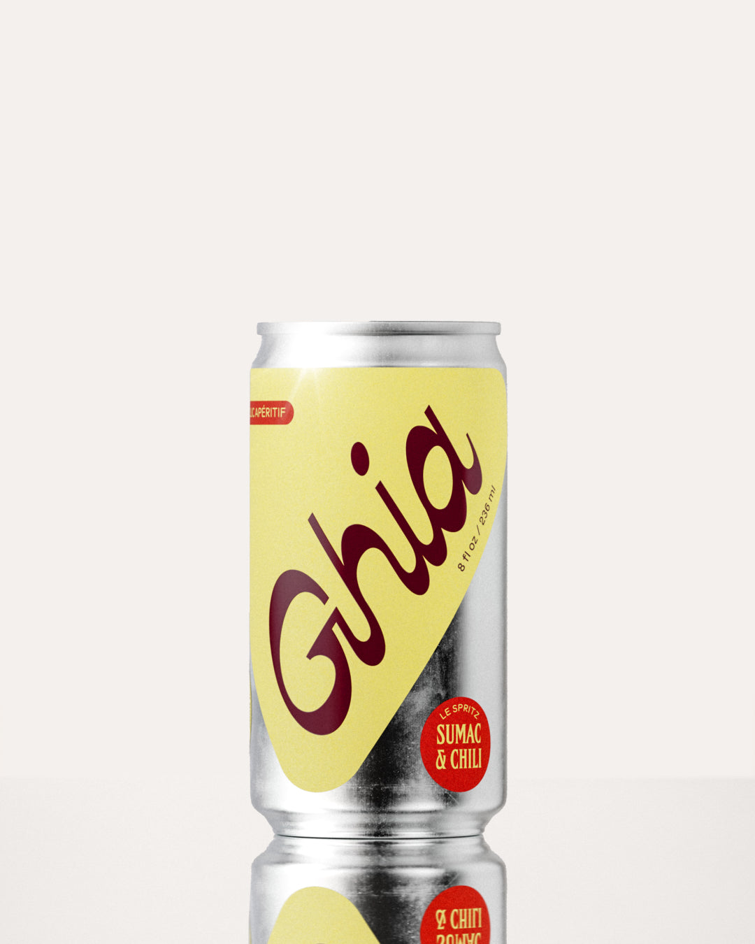 A Ghia non-alcoholic spritz can with a yellow label, burgundy lettering, and a silver aluminum body, featuring a sumac and chili flavored non-alcoholic spritz beverage.